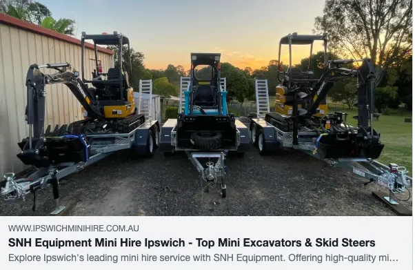 Three mini excavators on trailers at sunset.