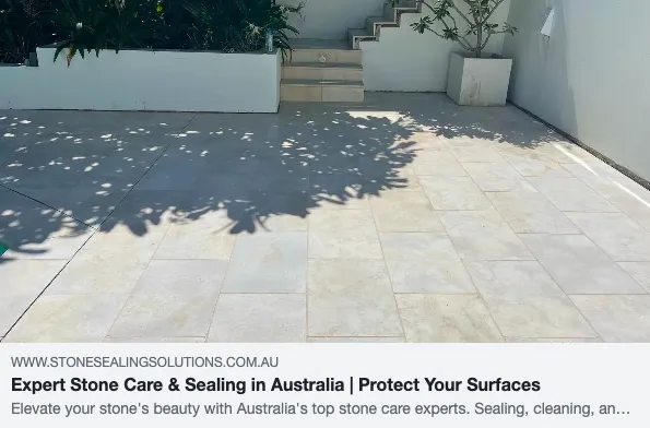 Outdoor stone patio with stairs and plants.